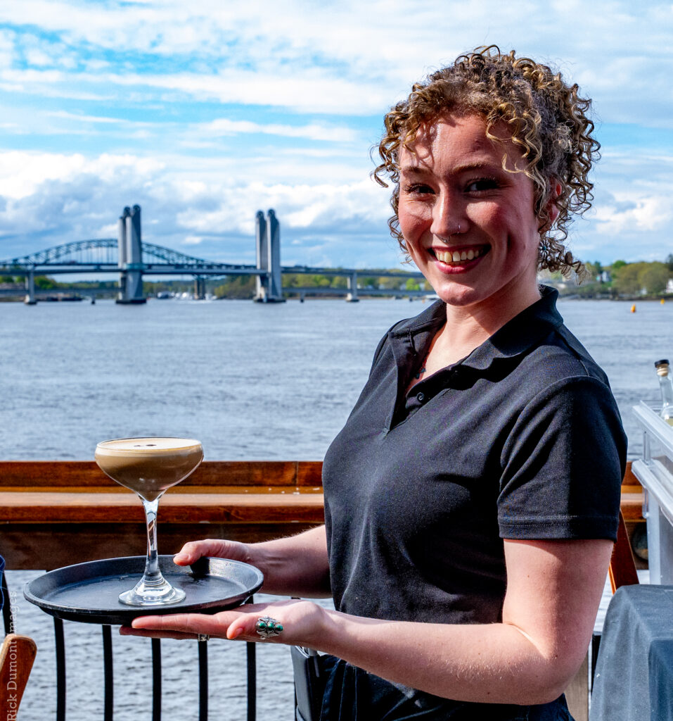 Server holding a drink beside Portsmouth Harbor